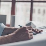 Pessoa desenhando em uma cartolina