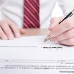 Pessoa assinando um documento