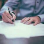 Homem assinando um papel