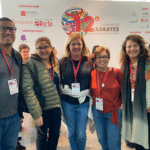 Cristina Gonzales em frente o painel do 12º congresso ABRATES