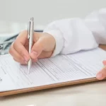 Pessoa escrevendo no papel médico